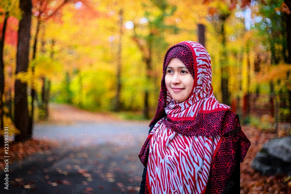 Muslim woman in Canada during autumn with colorful maple leaf as background Muslim woman in Canada during autumn with colorful maple leaf as background