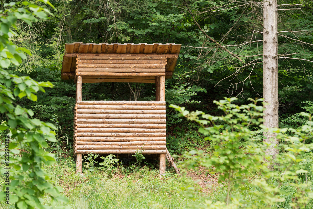 Green forest with wooden deer stand for hunters Green forest with wooden deer stand for hunters