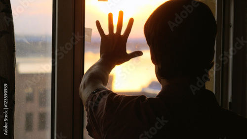 Man touch the sun on the window  sunshine city background