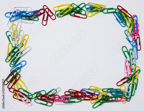 Frame of colorful paper clips isolated in white