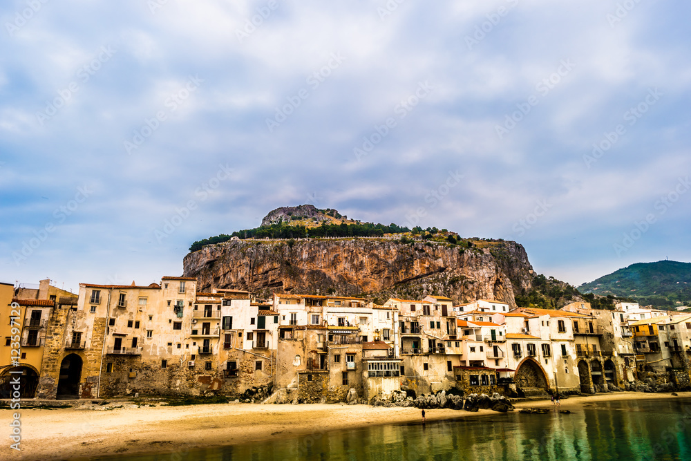 View on habour and old houses in Cefalu at sunset, Sicily. Beautiful townscape of old italian town. Travel photography.