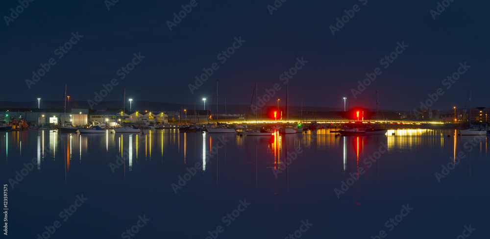 The moon and cityscape lights, reflect off harbour waters, poole The moon and cityscape lights, reflect off harbour waters, poole