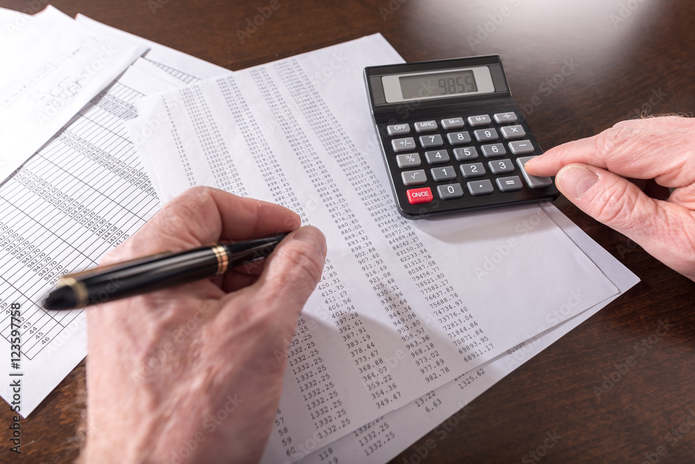 Male hand using calculator Male hand using calculator