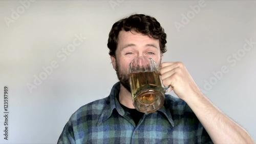 Model released man in studio guzzles entire beer and lets out a good burp and smile.
