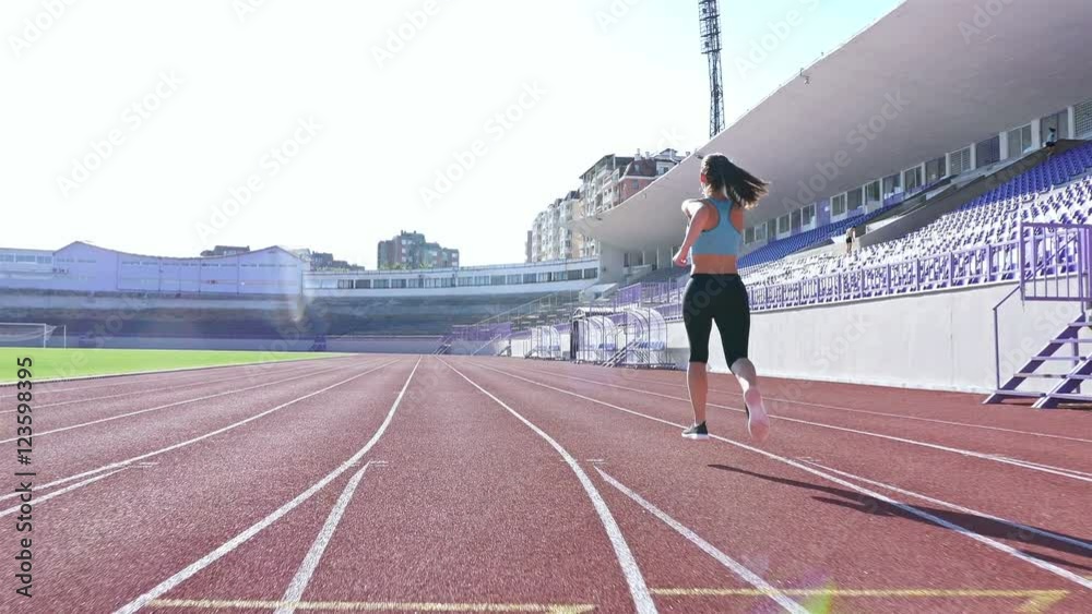 Tracking camera of a track runner athlete woman girl running at a stadium