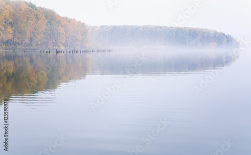 Fog on the lake Senezh in Solnechnogorsk fall in calm weather. Autumn water landscape