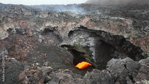 Eruption active Tolbachik Volcano on Kamchatka - viscous red hot lava flows into the hole of the lava flow. Russia, Far East, Kamchatka Peninsula, Klyuchevskaya group of volcanoes.