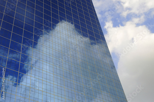 Cloud and sky reflection in windows of modern office building.