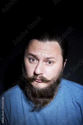 Young handsome bearded man with long beard moustache and brunette hair in studio