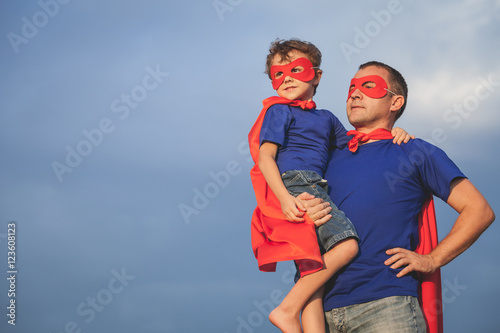 Father and son playing superhero outdoors at the day time. © altanaka