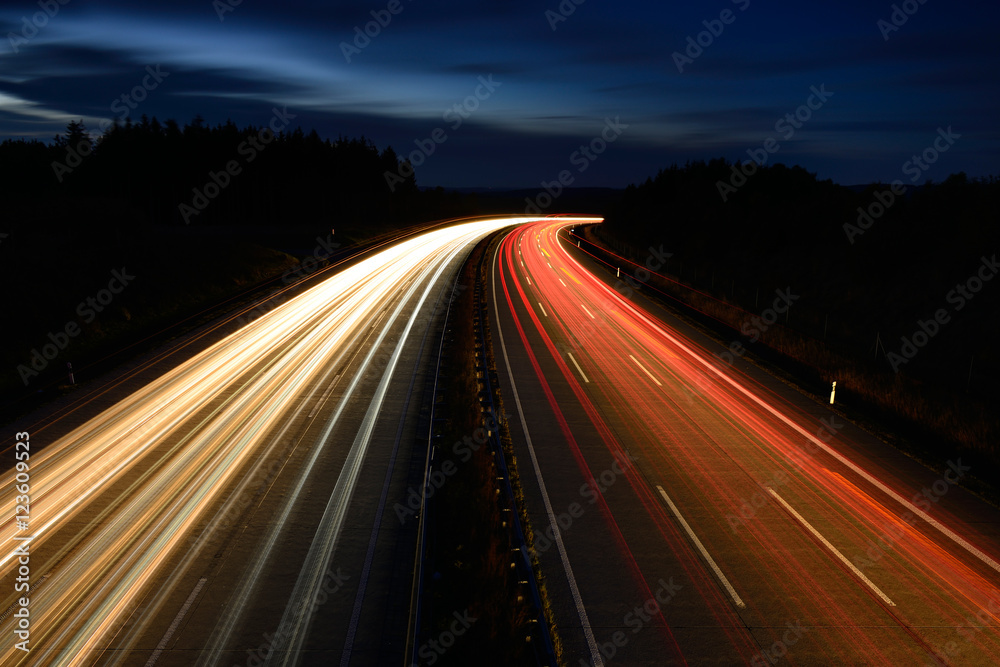Winding Motorway at night, long exposure of headlights and taillights in blurred motion - obrazy, fototapety, plakaty 