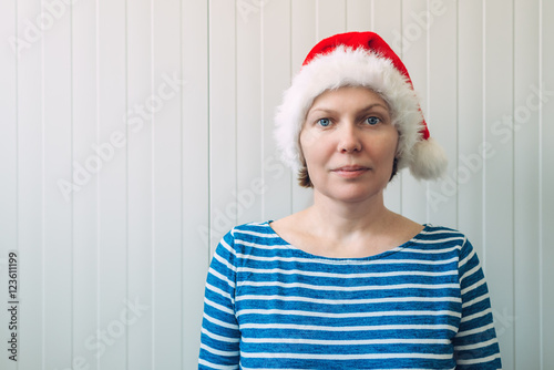 Portrait of beautiful adult caucasian woman with Santa Claus hat