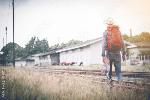 backpacker walking on railroad hand holding map with vintage fi