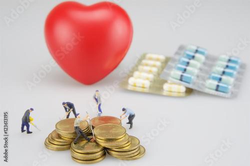 Piles of coins and heart with medicine photo