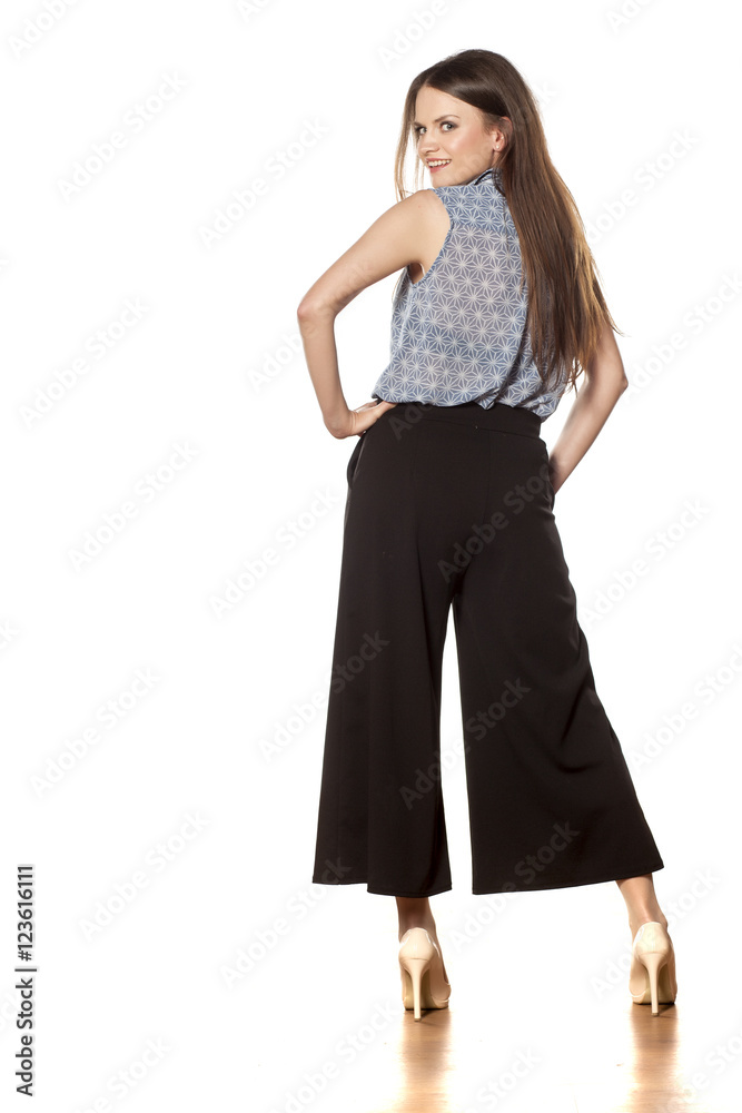 back view of a young beautiful woman with baggy trousers back view of a young beautiful woman with baggy trousers
