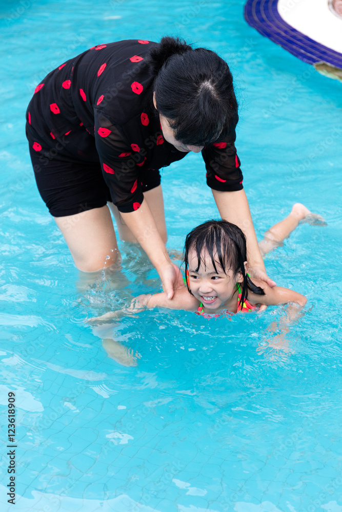 Asian Chinese Mom Teaching Little Girl Swimming At The Pool