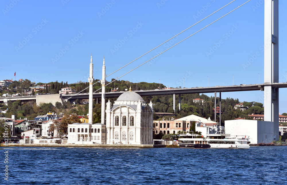 Ortakoy square and Ortakoy mosque on sunny day with the Bosphorus bridge behind