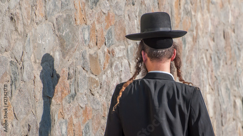 Jew Hasid ethnic headdress. Human shadow on stone wall. photo