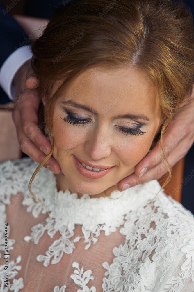 Man's hands hold a stunning bride's face Man's hands hold a stunning bride's face