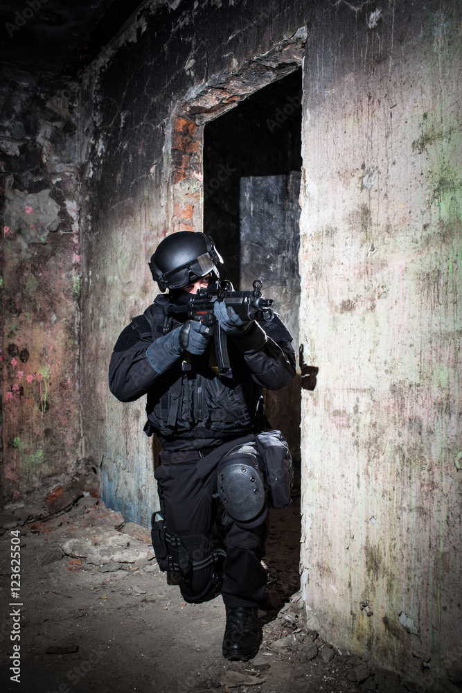 Fototapeta premium Special forces/ anti-terrorist police unit/private military contractor during night CQB hostage rescue raid/operation/mission (very harsh light for underline the atmosphere)
