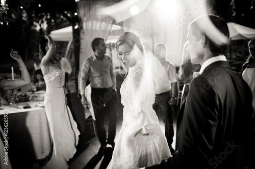Fototapeta Lamps lights envelope a stunning bride dancing with guests
