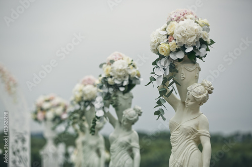 The figures with flowers on the wedding ceremony photo