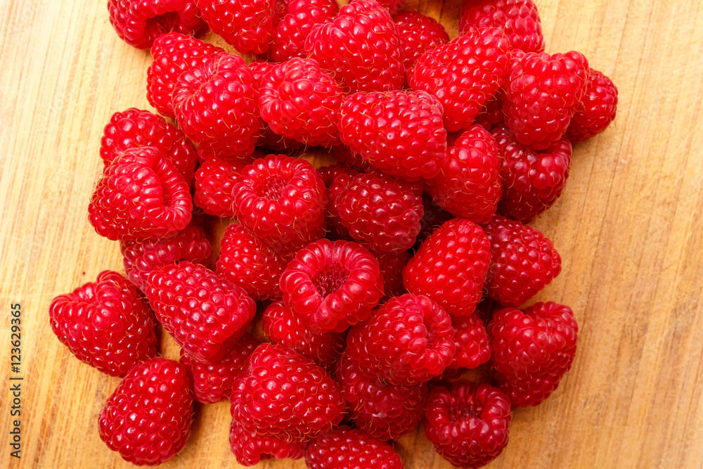 Raspberry berries on a wooden surface background Raspberry berries on a wooden surface background