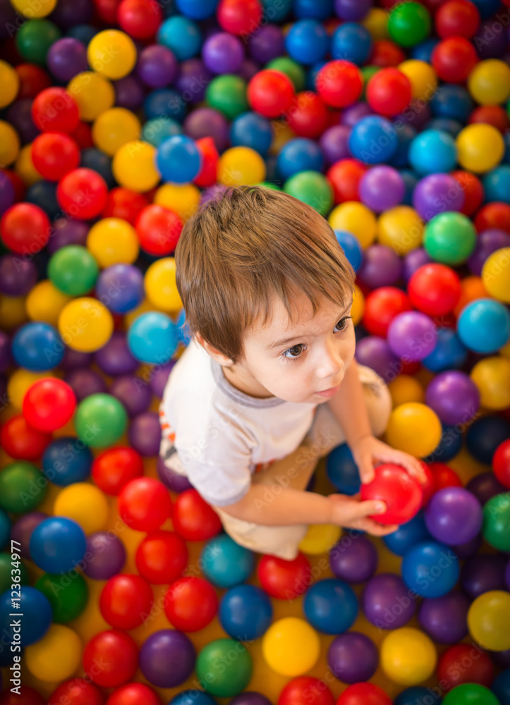 Happy cute child playing and having fun at kindergarten with col