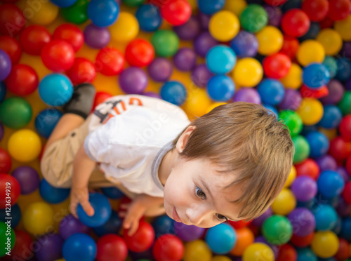 Happy cute child playing and having fun at kindergarten with col