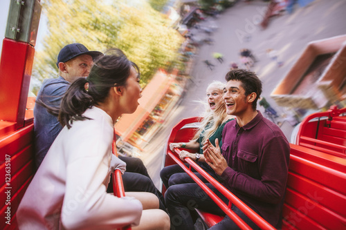 Foto Happy young friends having fun on amusement park ride