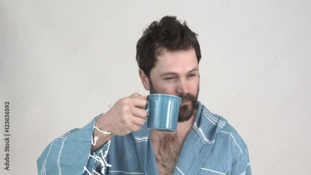 Model released man in studio enjoys a cup of coffee in the morning while still in his robe, 2 clip sequence. Model released man in studio enjoys a cup of coffee in the morning while still in his robe, 2 clip sequence.