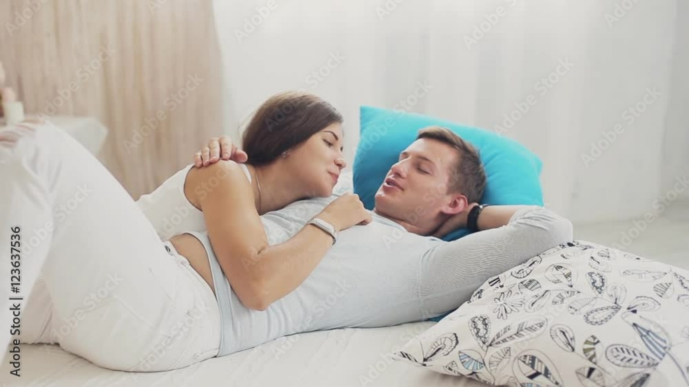 High angle view of couple hugging in bed
