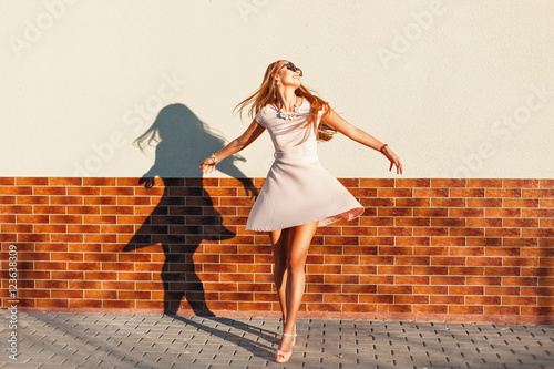 Fényképezés Beautiful young cheerful woman with a smile in a pink dress