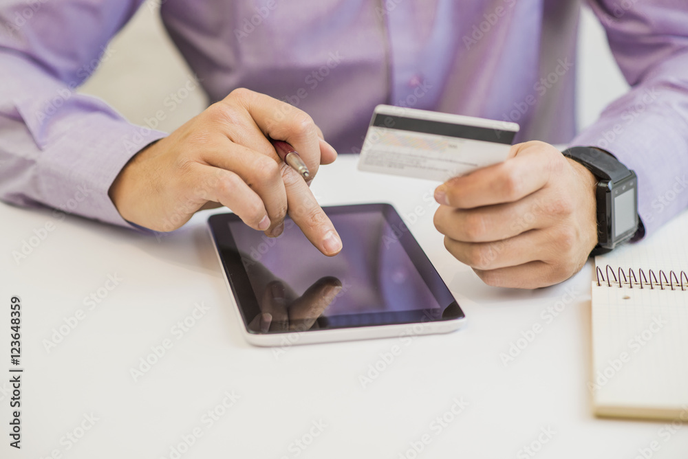 Businessman using a credit card and digital tablet for buying on line Businessman using a credit card and digital tablet for buying on line