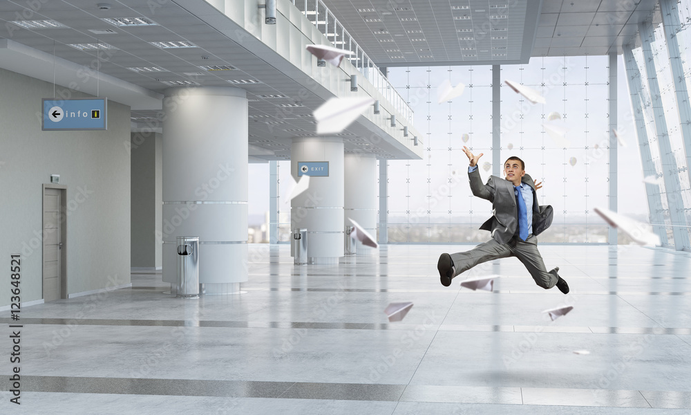 Fototapeta premium Dancing businessman in office room . Mixed media