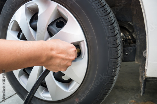 man filling air pressure in the car tyre © Piman Khrutmuang