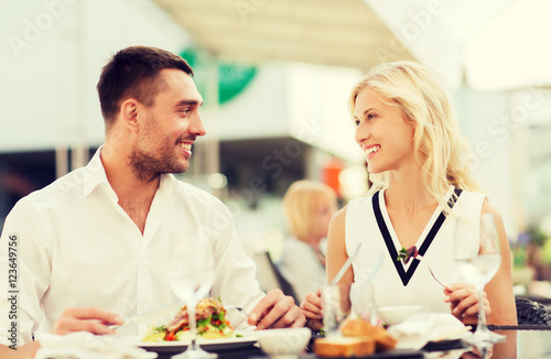 happy couple eating dinner at restaurant terrace