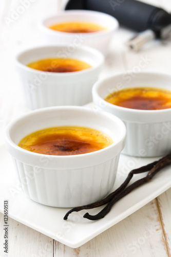 Traditional French creme brulee dessert with caramelized sugar on top, on wooden table