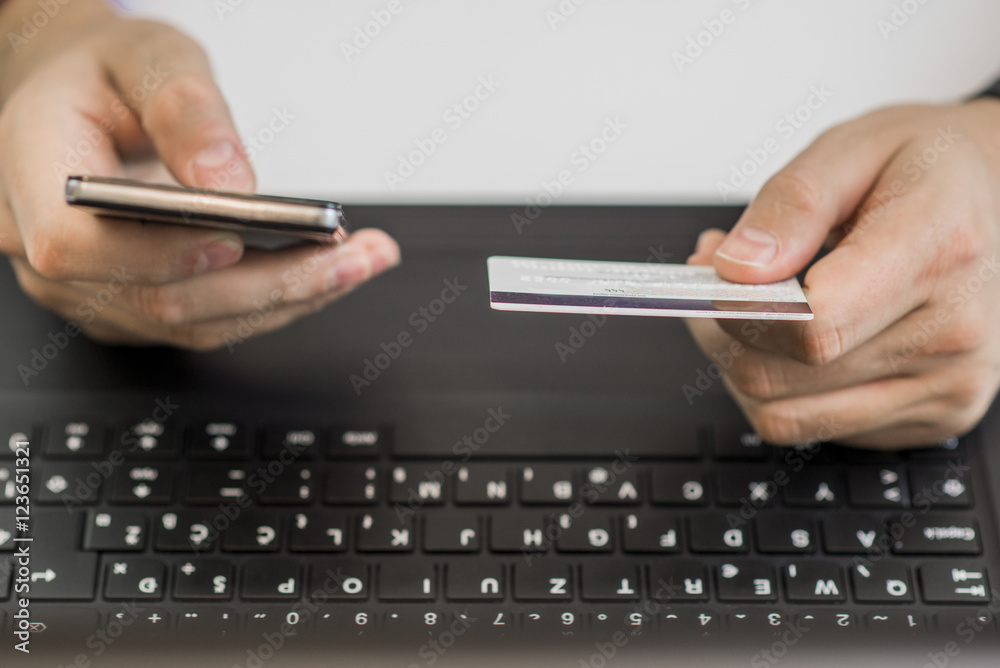 Online payment,Man's hands holding a credit card and using smart phone Online payment,Man's hands holding a credit card and using smart phone