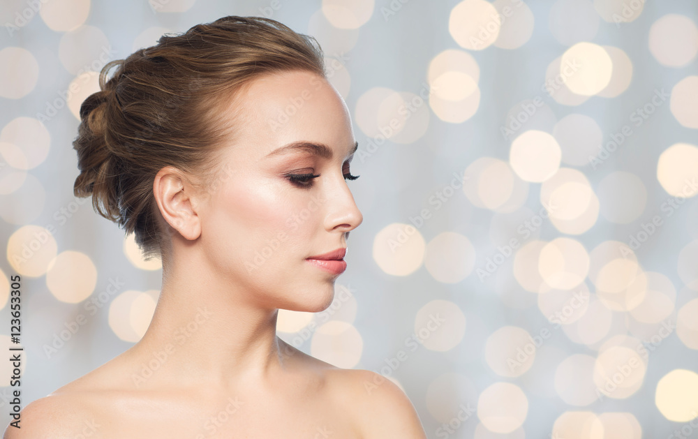 Naklejka premium beautiful young woman face over holidays lights