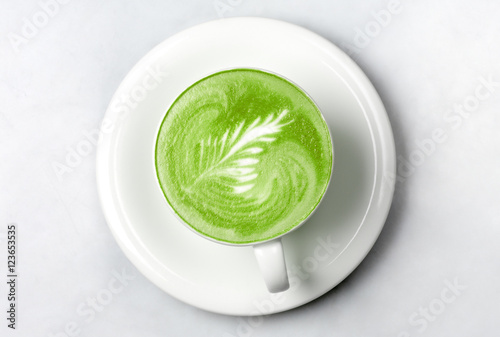 cup of matcha green tea latte over white