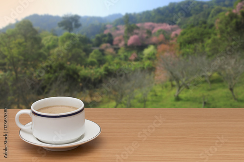 coffee on wooden table with nature background