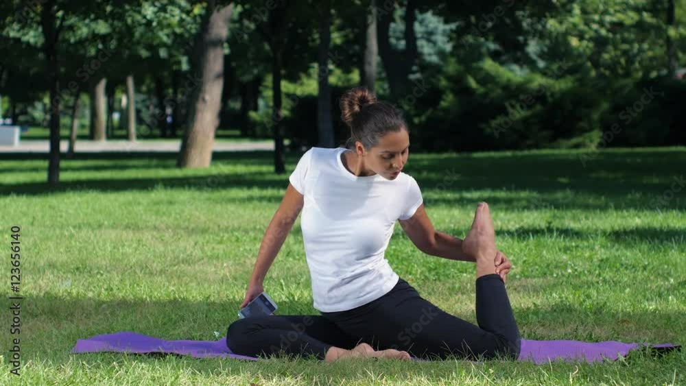 Girl makes a selfie doing yoga. Sunny day in park Girl makes a selfie doing yoga. Sunny day in park