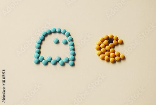 Color Candy pac man with ghost chasing it on white background arranged in pac-man style. Funny game with food,  closeup. Halloween holidays
