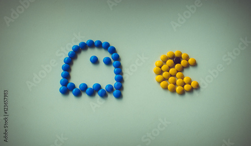 Color Candy pac man with ghost chasing it on white background arranged in pac-man style. Funny game with food,  closeup. Halloween holidays