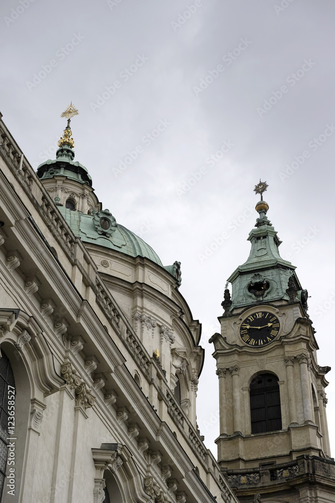 Fototapeta premium The dome and clock tower of St Nicholas church in the City of Prague, Czech Republic