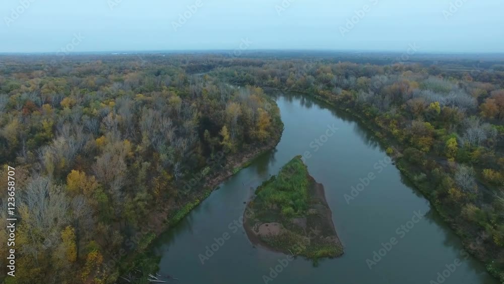 Aerial video of a small river flowing through the forest at cloudy day. Drone moving forward at high altitude. 4K Aerial stock footage shot at autumn season time.
Aerial video of a small river flowing through the forest at cloudy day. Drone moving forward at high altitude. 4K Aerial stock footage shot at autumn season time.