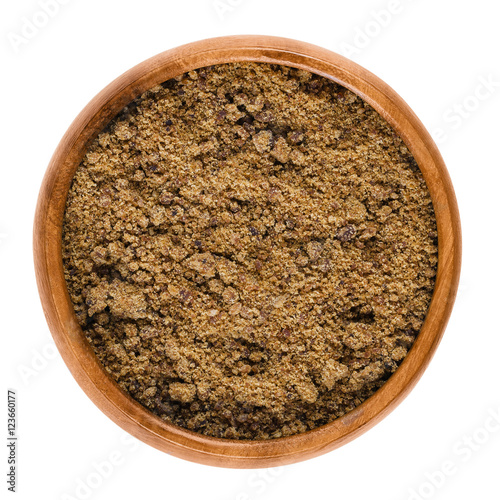 Muscovado dark brown sugar in a bowl over white. Also called Khaand, unrefined non-centrifugal cane sugar with strong molasses content and flavor from the Philippines, used in baking and making rum.
