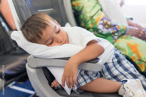 Kid sleeping inside the airplane during the flight