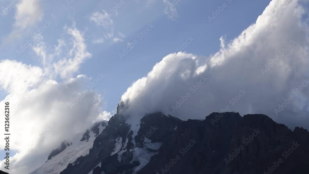 clouds crash into a high mountain peak clouds crash into a high mountain peak